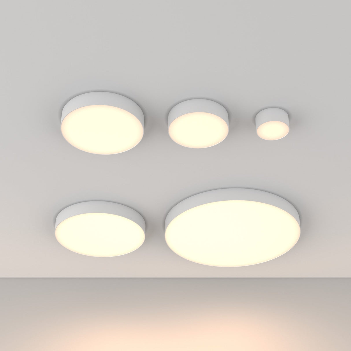 Five Zon LED Large Flush Ceiling Lights, white and of varying sizes, are evenly spaced on a white ceiling. Each emits a soft, warm glow (3000K), enhancing the minimalist design with their 90W power and creating a modern interior aesthetic.