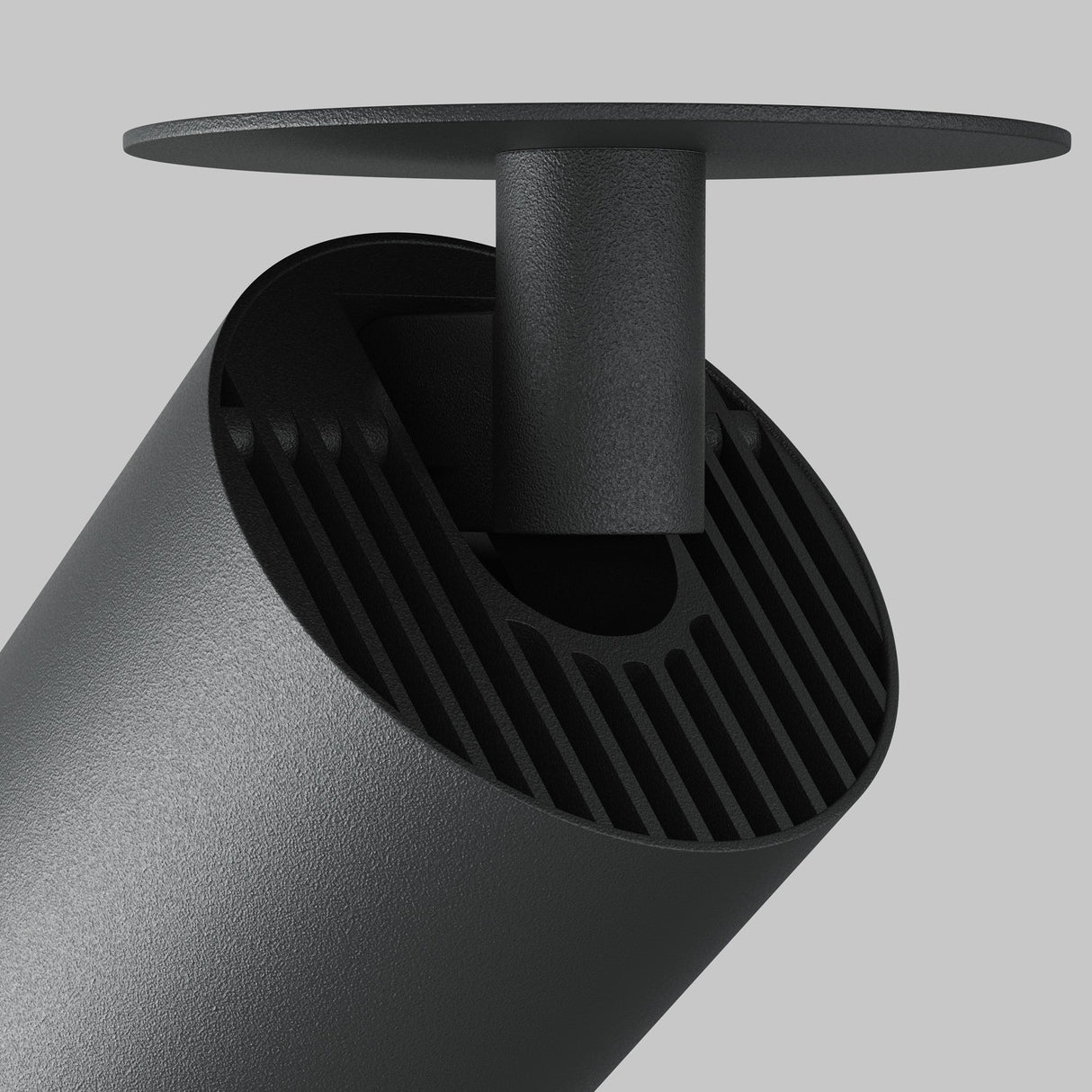 Close-up of the Focus LED Single Recessed Spotlight in black. This modern minimalist 12W, 4000K fixture is designed for task lighting with a cylindrical shape, angled round base, and grooves near the LED spotlight source against a plain grey background.