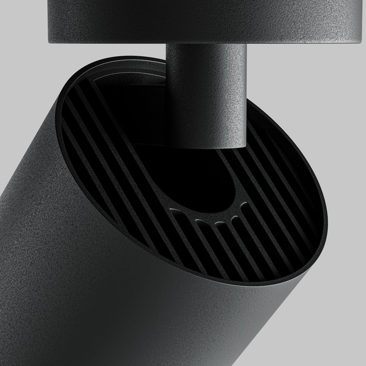 Close-up of the Focus Zoom LED Single Surface-Mounted Spotlight 12W 4000K in black, showcasing a modern cylindrical design with an open top and vertical grooves against a plain gray background, featuring LED spotlight technology for enhanced ambiance.