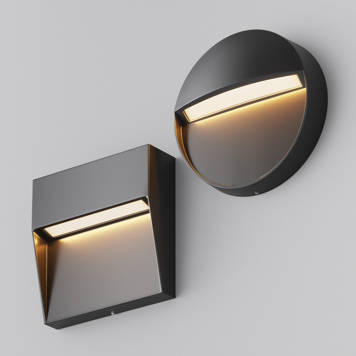 On a gray background, two modern wall lights are displayed: on the left, the Mane Outdoor LED Square Wall Light in black with a slanted top, and on the right, a circular light with a curved top. Both fixtures emit warm, downward light showcasing a sleek, minimalist design with energy-efficient features.