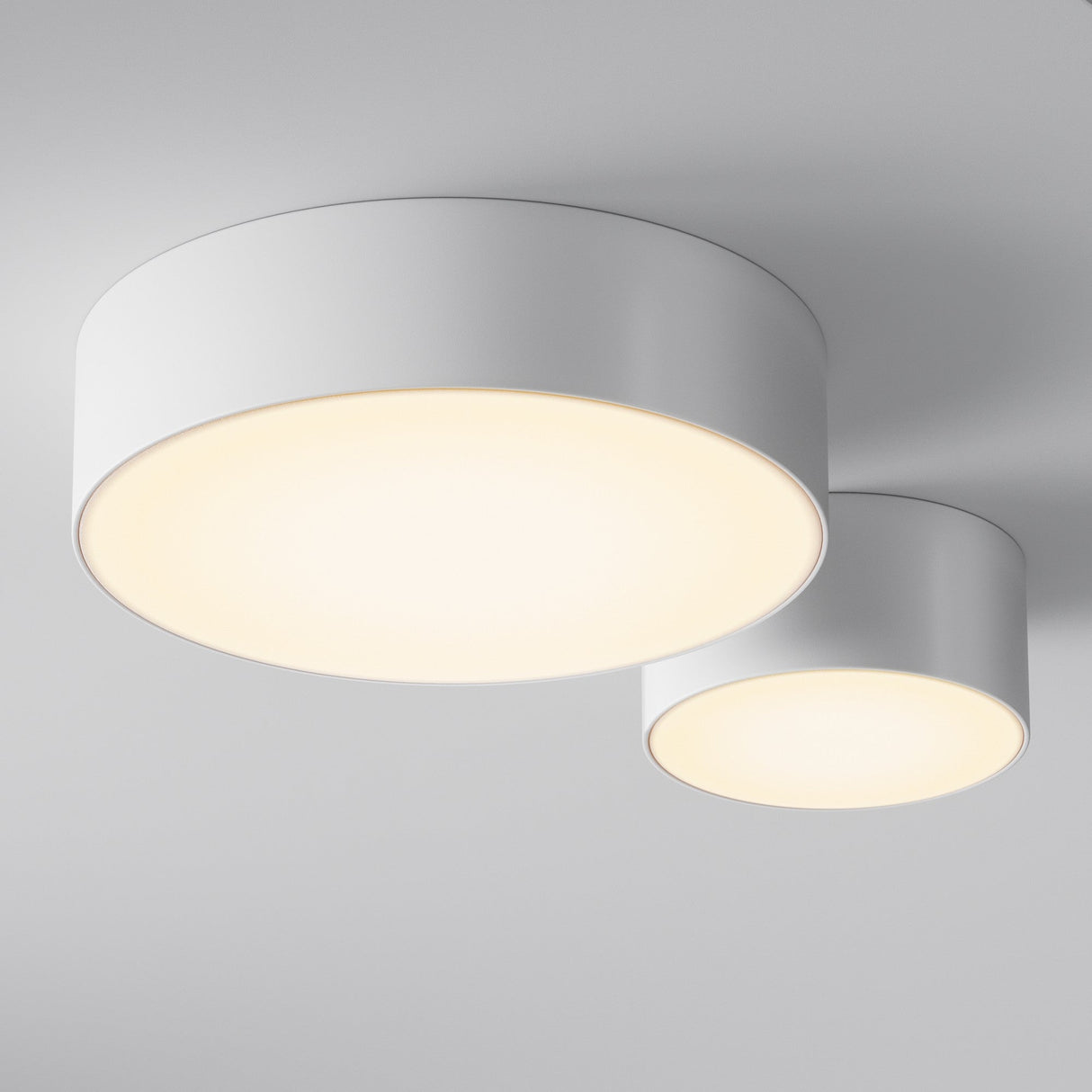 The ceiling boasts two modern, round, white Zon Outdoor Ceiling Light 30W 3000K fixtures. One is larger, both offering a warm glow and even illumination. With an IP65 rating, they are perfect for versatile outdoor use.
