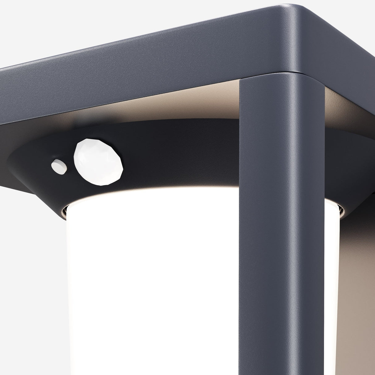 Close-up of the Shatter Outdoor Wall Light 3000K - Graphite, featuring a modern cylindrical design with matte black frame and white light diffuser. It includes an upper motion sensor powered by an efficient solar battery for sustainable illumination.