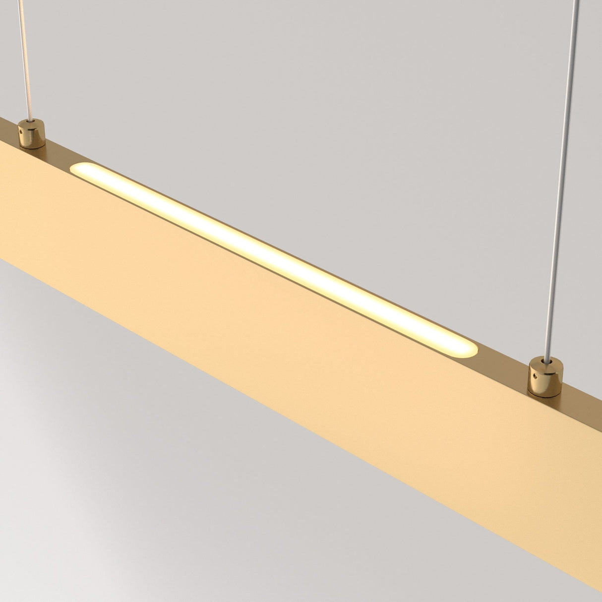 The Step LED Linear Suspension Light 3000K 23W in Gold features a minimalist rectangular design, hanging elegantly by two thin cables. It provides efficient lighting with a warm, soft glow, casting subtle illumination against the plain gray background.