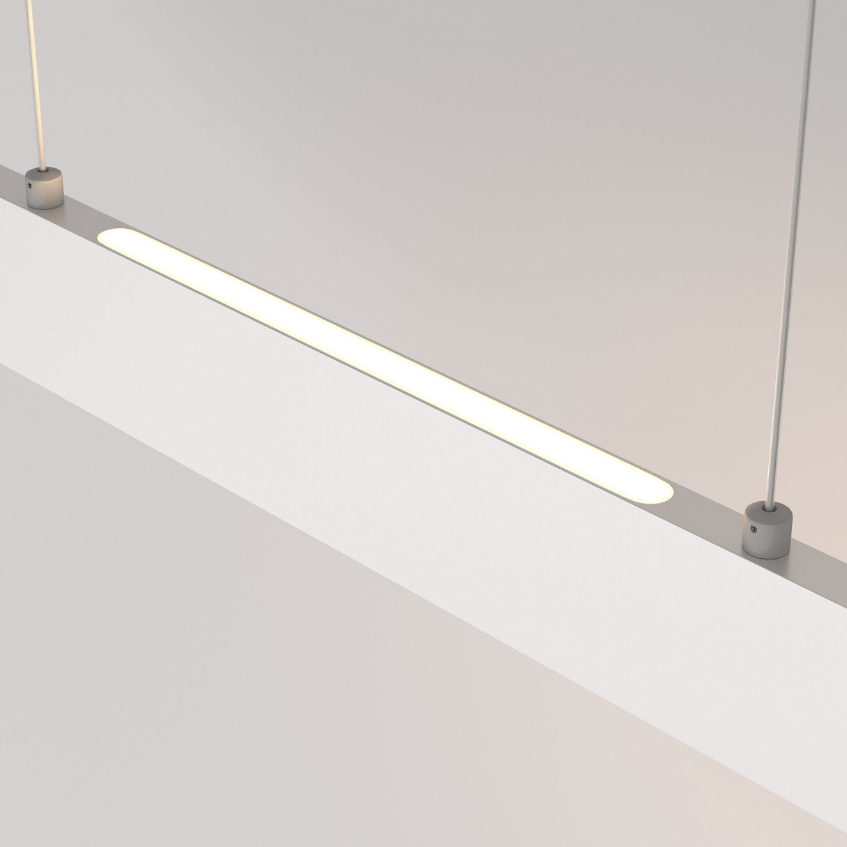 The Step LED Linear Suspension Light 3000K 23W in White hangs elegantly, showcasing a sleek, minimalistic design with dual cables on each end. It provides energy efficiency and emits a soft, warm glow that enhances any modern spaces aesthetic.