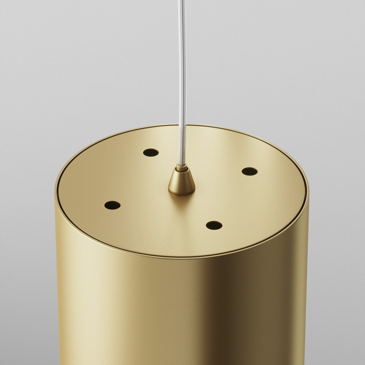Close-up of the Polar Short Round Pendant Light in matte gold, featuring a smooth finish with four small holes on top and a central white cord attachment against a light gray background, highlighting its elegant design.