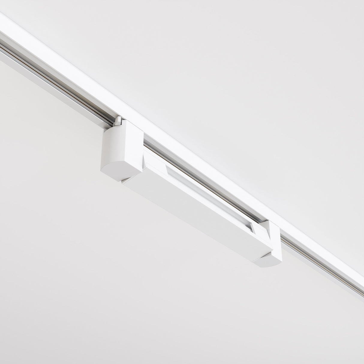 The Points Rot LED Swivel Linear Track Light for Single Phase Track Unity 10W 4000K 36° - White is a sleek, modern fixture mounted on a plain white ceiling. Its minimalist design and high CRI provide clean lines and a contemporary aesthetic.