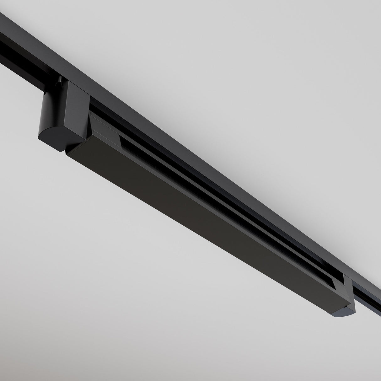 Close-up of the black Points Rot LED Swivel Linear Track Light installed on a white ceiling. This modern, minimalist fixture has clean lines and an elongated design parallel to the ceiling, emitting warm 3000K light.