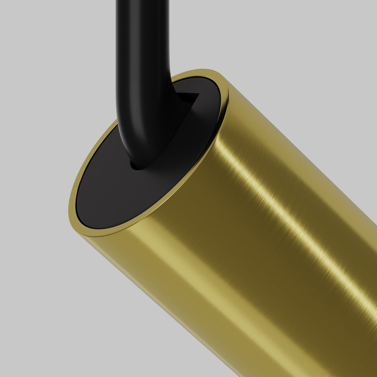 Close-up of the Focus LED Magnetic Exility Track Spotlight with a sleek cylindrical design in brushed brass and black, reminiscent of modern aesthetics, standing against a gray background.