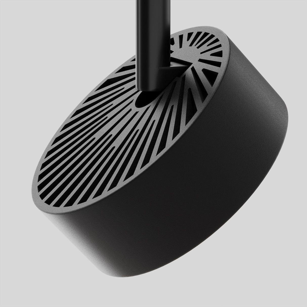 A modern black cylindrical object, similar to the Rado DALI CCT LED Dimmable Magnetic Exility Track Spotlight 18W 2700-6000K, features slotted patterns on top. It hangs by a central rod against a light gray background, offering an elegant dimmable lighting solution.