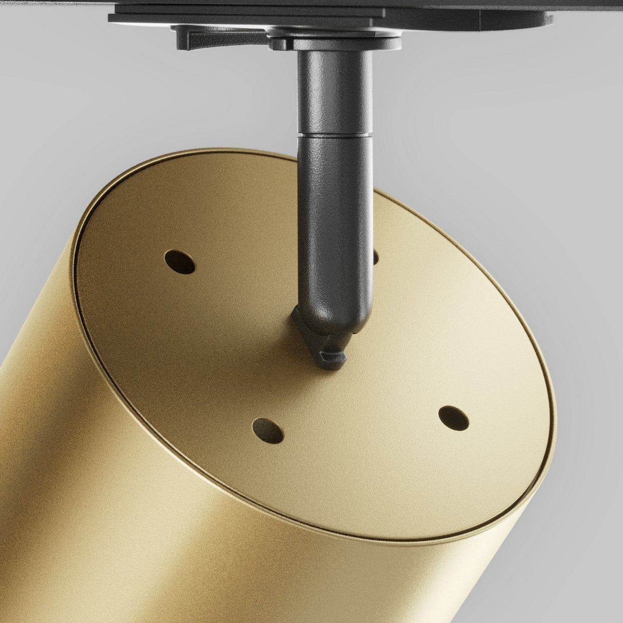 Close-up of the Polar LED Single Phase Unity Track Spotlight in matte gold, featuring a modern cylindrical design with a black mounting bracket and four small screw holes. Ideal for sleek, modern interiors against a gray backdrop.