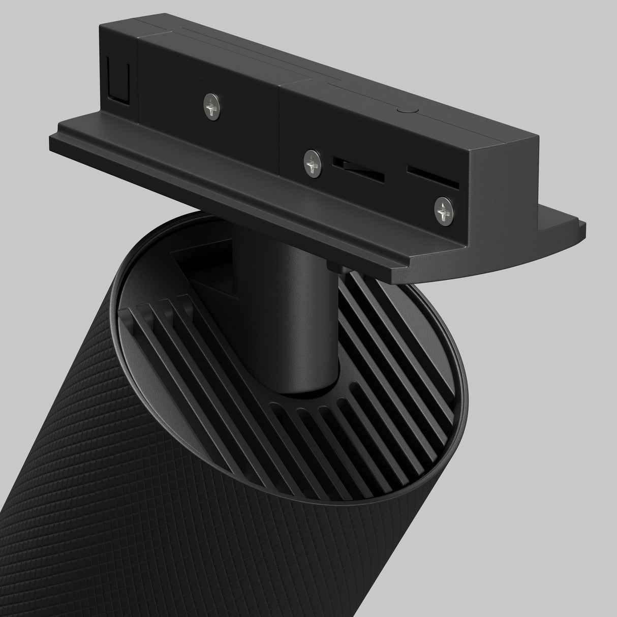 The Artisan Single Phase Unity Track Spotlight in black boasts a sleek, cylindrical design ideal for modern interiors. Its minimalistic look features a top panel with two screws and slots attached to a central support, complemented by textured surfaces for sophisticated appeal.