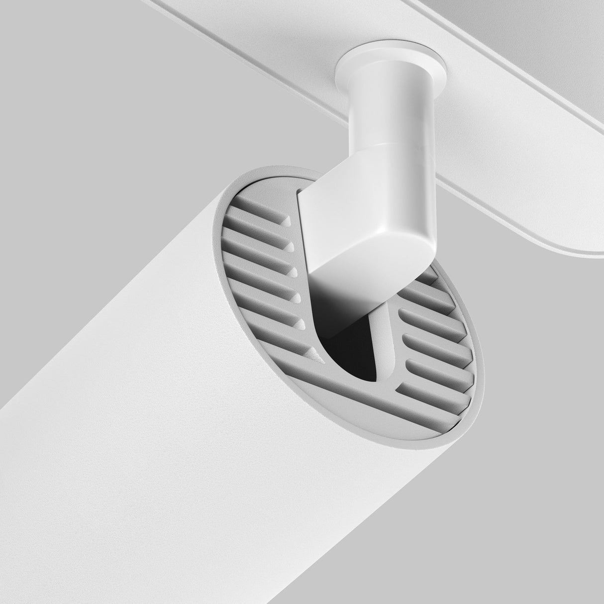 A close-up of the Focus LED Magnetic Radity Track Spotlight 12W 3000K - White displays a modern cylindrical design with vent-like grooves, resembling an adjustable swivel system. Mounted on a rectangular base, it creates a sleek minimalist look against a light gray background.