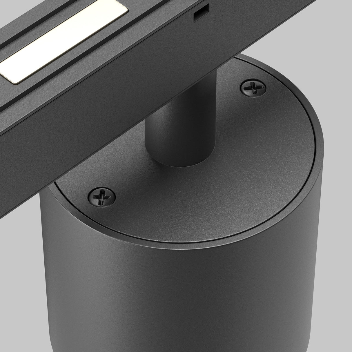 A close-up of the Alfa S CCT LED Dimmable Magnetic Exility Track Downlight in black showcases its modern, minimalistic design. The lamp features a cylindrical base with visible screws and a flat arm housing an LED downlight with adjustable 2700-6000K color temperature against a neutral gray background.