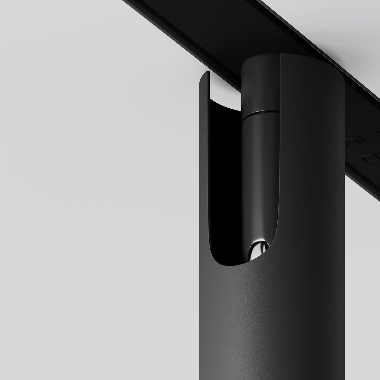 The Focus T LED Magnetic Exility Track Spotlight, a sleek black cylinder in a vertical casing, stands out against a light gray background. Its minimalist design and clean lines exemplify energy-efficient 3000K lighting with style.