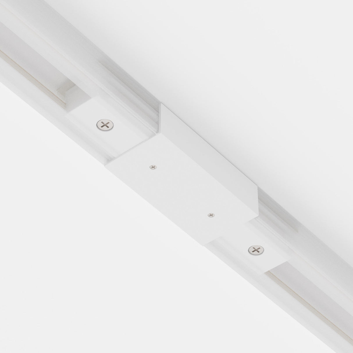 Close-up of a Unity Single Phase Track Middle Feed Connector in white. Its ceiling-mounted, with visible screws and a track running parallel for adjustable fixtures, seamlessly blending into flexible lighting setups against a plain white background.