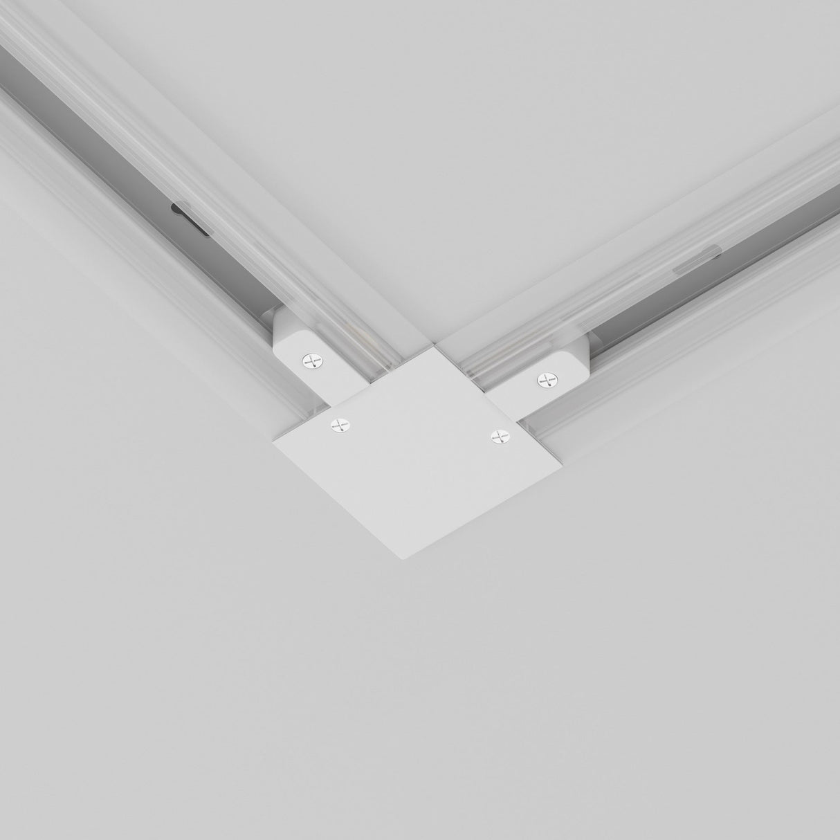 The Unity Tracks Recessed L-Shaped Connector in white, ideal for minimalist interiors, features visible corner screws and seamlessly joins two ceiling-mounted rails at a right angle, integrating smoothly into a white ceiling for track lighting.