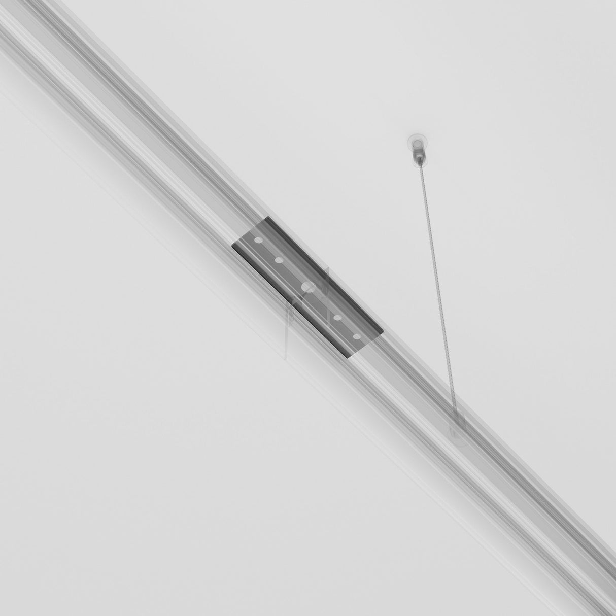 The Exility Magnetic Surface-Mounted Track Straight Connector in black is suspended by two thin cables from the ceiling. With a minimalist, long rectangular design and subtle silver accents, it adds elegance as both a stylish lighting system accessory and a contemporary fixture against the white ceiling.