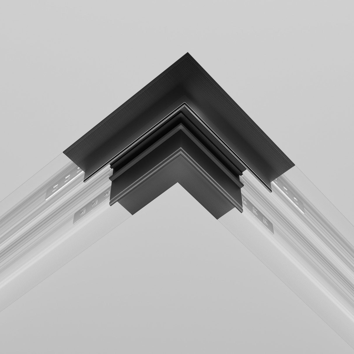 Close-up view of the Exility Tracks L-Shape Corner Connector, built-in for 12.5mm plasterboard, showcasing overlapping black and gray layers. This metallic joint forms a sleek geometric pattern against a light gray backdrop, enhancing the allure of contemporary interiors.