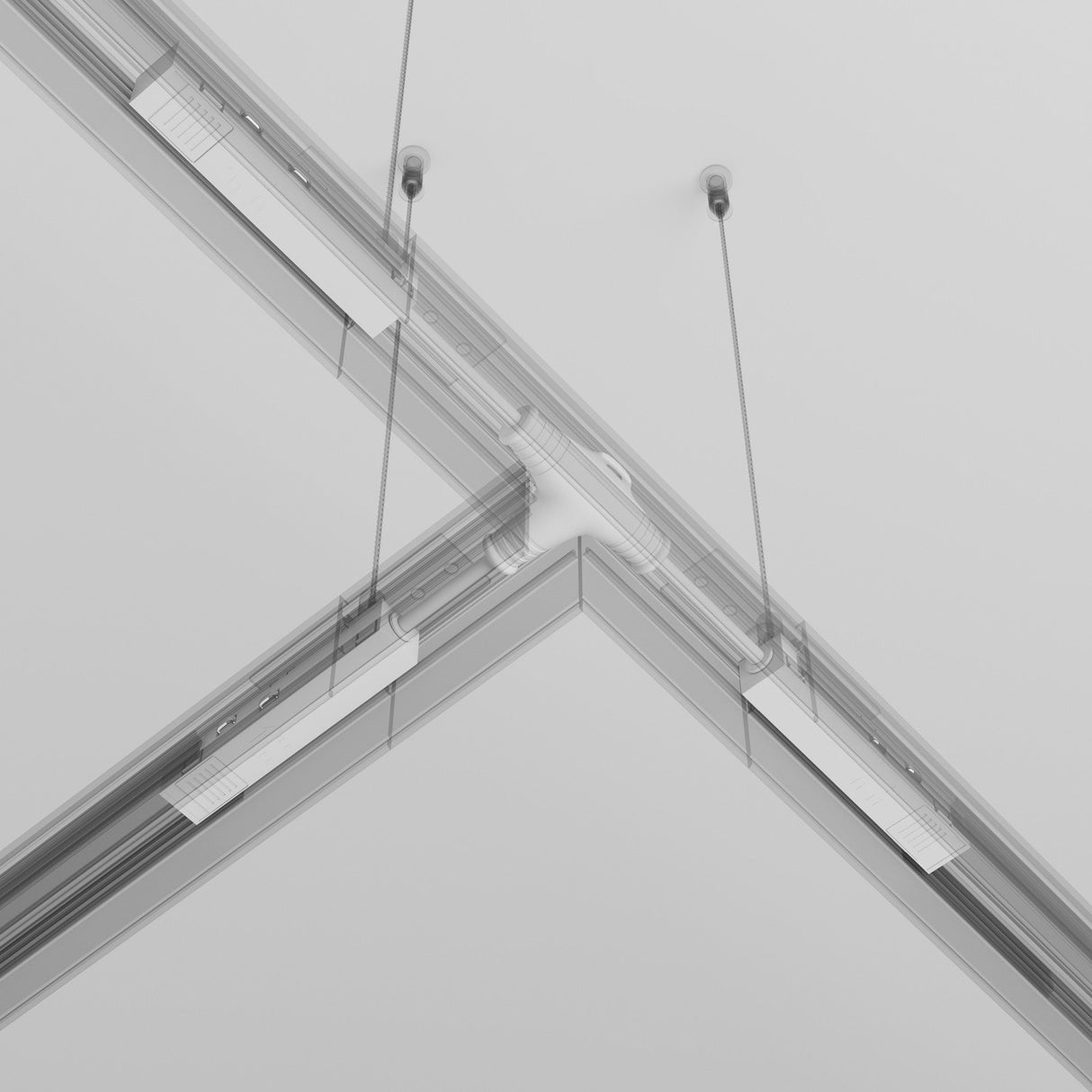 The modern suspended ceiling showcases sleek metallic rails in a geometric pattern with two thin vertical cables. It features the Exility Tracks Magnetic T-Connector Power Feed in white, emphasizing clean lines and symmetry alongside subtle multi-directional lighting layouts.