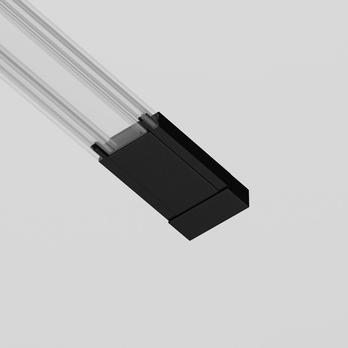 A close-up of the Radity Magnetic Track Surface Power Feed in black, featuring a modern linear LED design with clear elements. This fixture, part of a sleek track lighting system, hangs from the ceiling and highlights minimalist styling against a neutral backdrop.