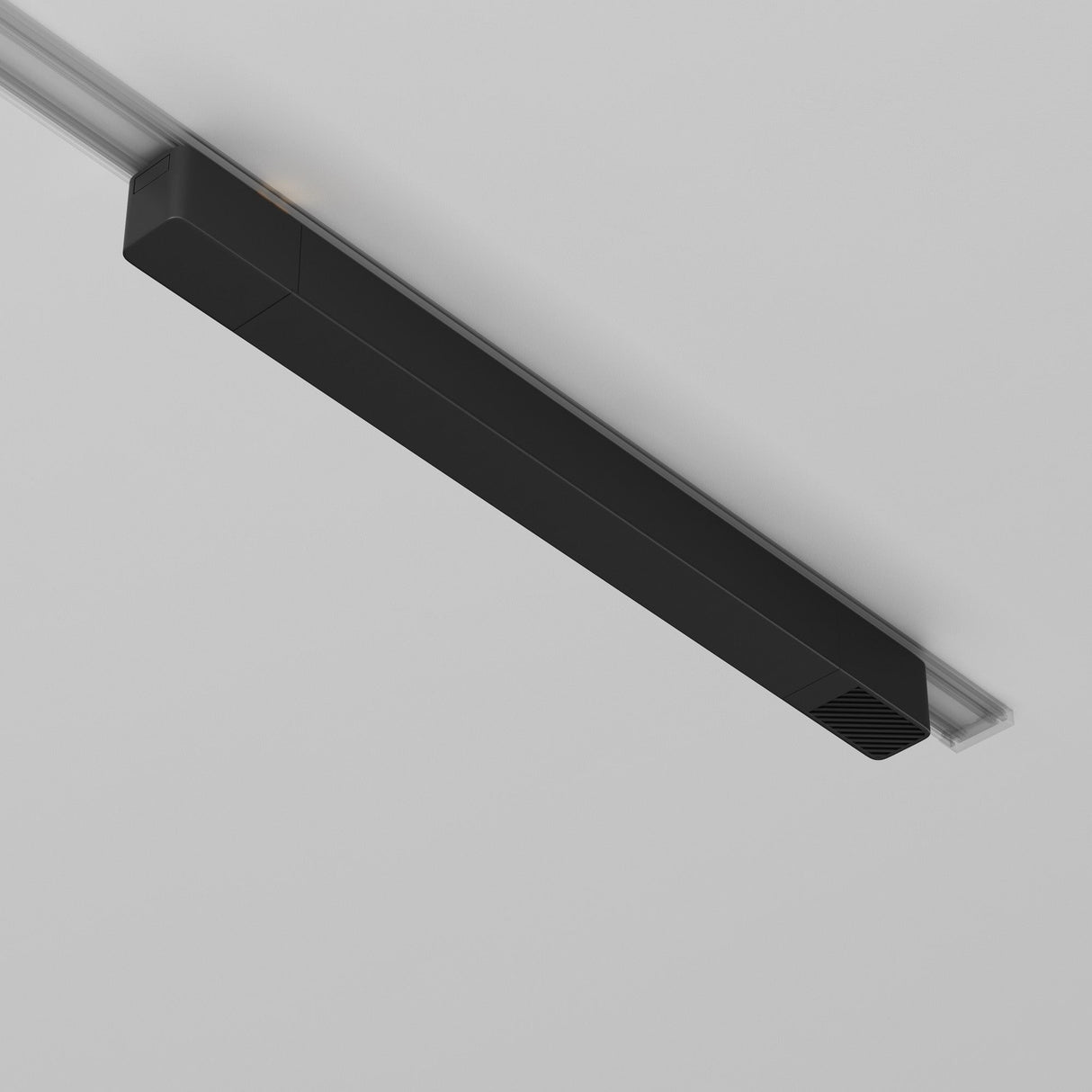 A sleek black linear light fixture from the Radity Track Power Supply 100W is recessed into a white ceiling. Its minimalist design and clean lines offer a modern aesthetic, blending seamlessly with the surface while highlighting the sophistication of magnetic track lighting.