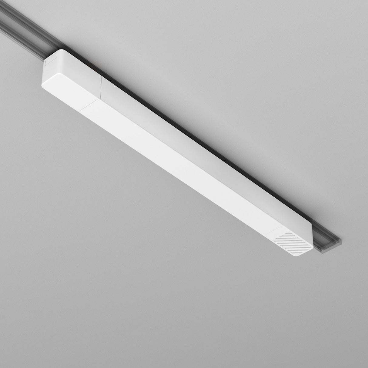 A sleek Radity Track Power Supply 100W in white, with a modern rectangular design and subtle vent-like pattern, is mounted on the light gray ceiling. This magnetic track light fixture is discreetly powered by a 48V supply.