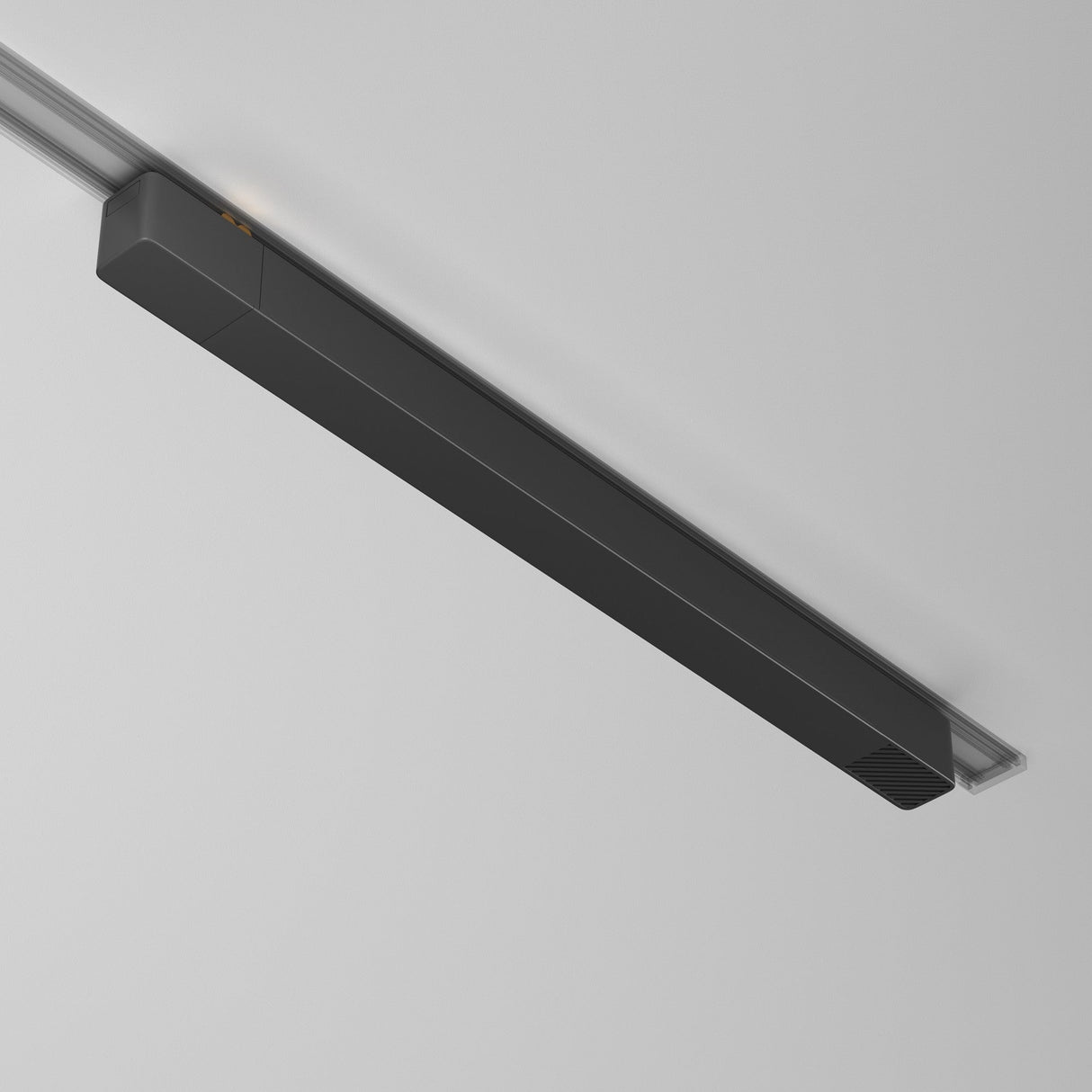 The Radity Track Power Supply 200W - Black is a sleek, modern linear LED fixture with a streamlined rectangular shape, seamlessly blending with a minimalist white ceiling due to its recessed installation.