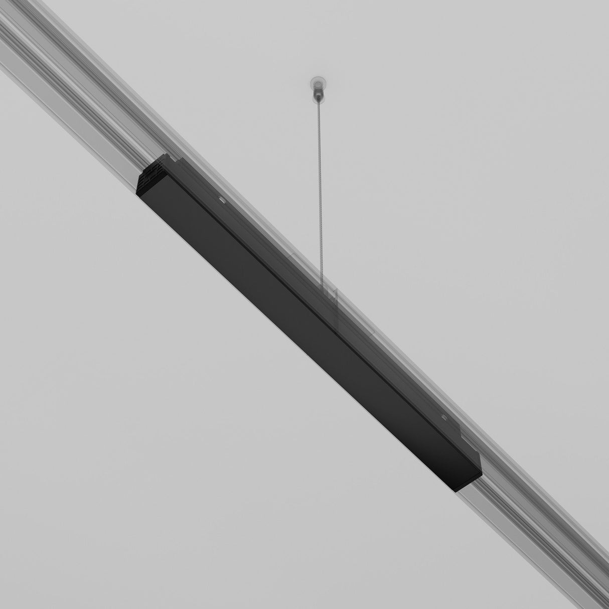 A sleek, modern black linear pendant light hangs from a vaulted ceiling, blending with recessed track lighting. With a thin cable highlighting its minimalist design against a neutral background, the fixture is powered by the Exility Recessed Track Power Supply 100W - Black.