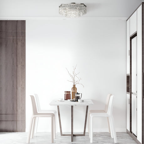 Minimalist dining area featuring a small table, two white chairs, and set with vases, a tray, and cups. A Dune 10 Light Flush in chrome and crystal hangs above. Neutral tones of white walls and wood accents provide a calm atmosphere.