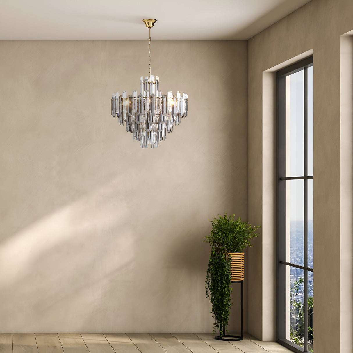 A modern minimalist room features the Flare 8 Light Chandelier in gold with crystal elements. A large window reveals a cityscape, and a tall plant in a woven basket enhances the wooden floor.
