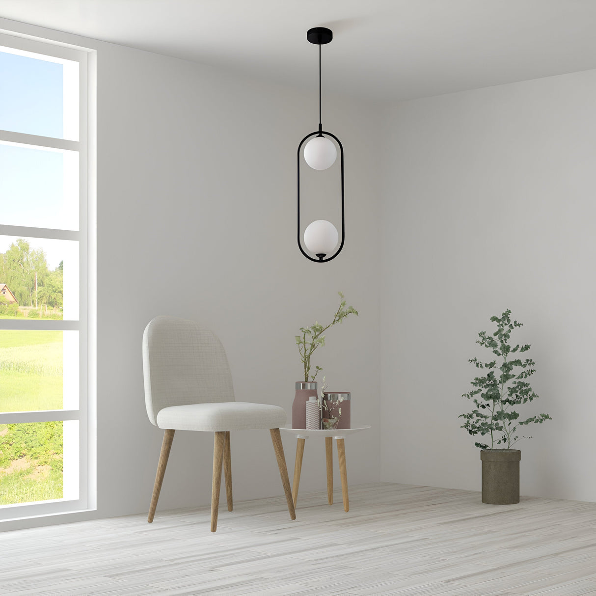 A minimalist room features a beige chair, a small round table with vases of greenery, and a potted plant on the wooden floor. A Ring 2 Light Pendant in black, with white glass spheres, hangs from the ceiling. A large window showcases a green landscape view.