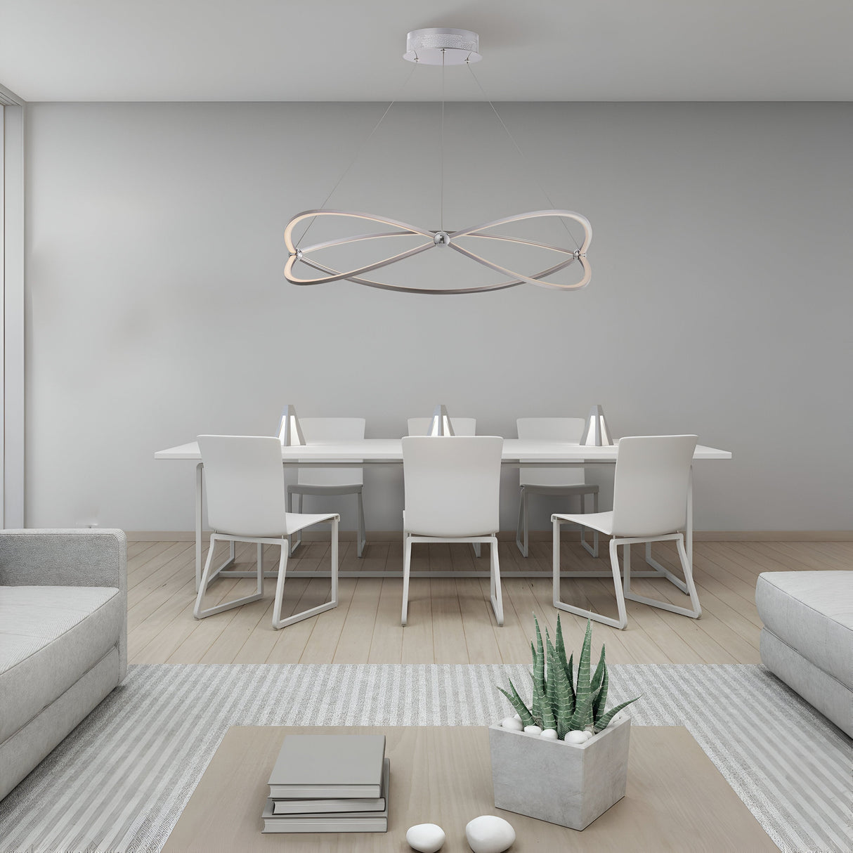 A minimalist dining room features the Weave LED Circular Suspension Light 3000K 56W - Nickel above a white table with matching chairs. A small succulent sits on a wooden coffee table, complemented by light wood flooring and neutral-toned furniture, highlighted by the nickel-finished frame.