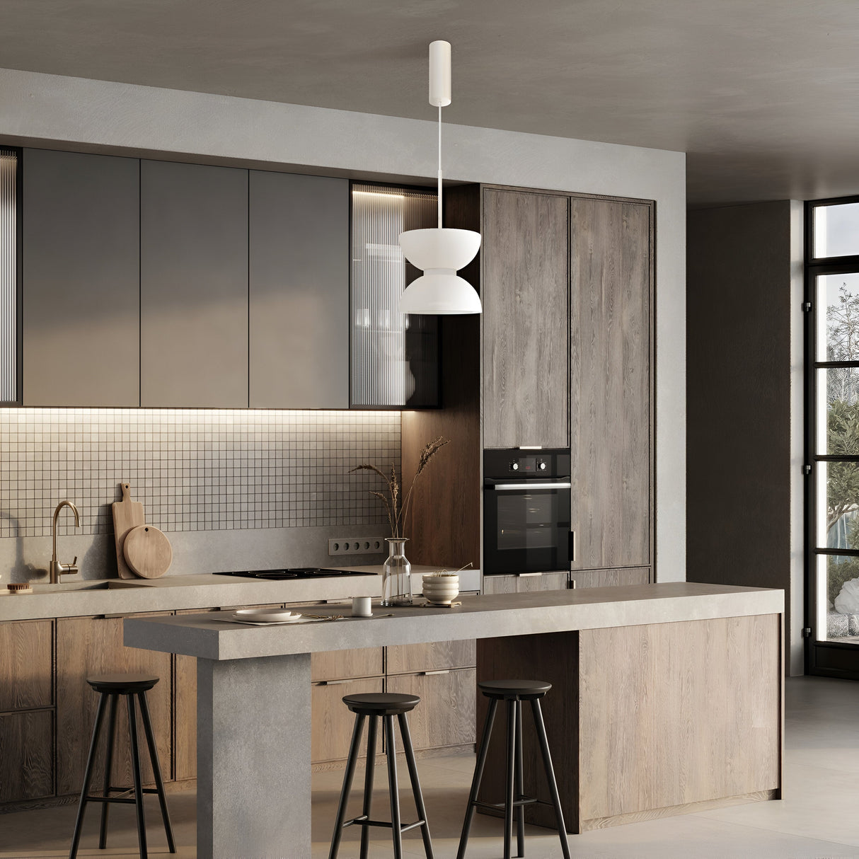 A modern kitchen with a minimalist design features a concrete island, three stools, wood cabinets, and a built-in oven. The Kyoto LED Pendant Light in white with glossy white glass hangs above the island. Neutral tones and natural light create an inviting atmosphere.