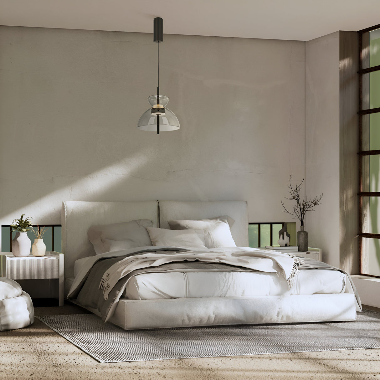 A serene bedroom features a large bed with white bedding and pillows, flanked by two small tables with vases. A modern touch is added by the Bangkok LED Pendant Light, 25cm - Black with Grey Glass Shade. Natural light fills the space through large windows, highlighting its neutral tones.