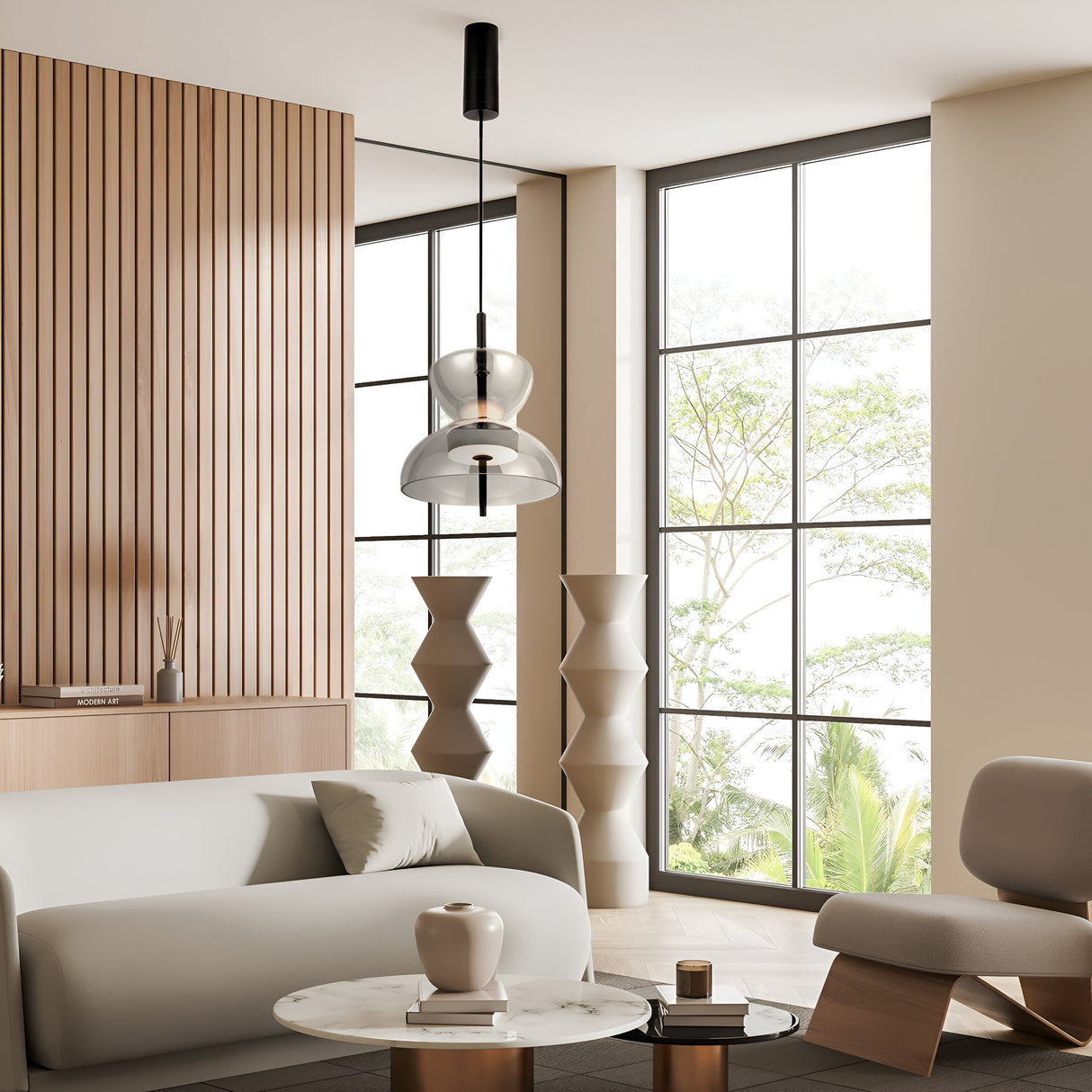 A modern living room with a light gray sofa, marble coffee table with a vase, geometric side tables, and the Bangkok LED Pendant Light in black with a smoky glass shade. Large windows showcase greenery outside, while wooden paneling and neutral paint adorn the walls.