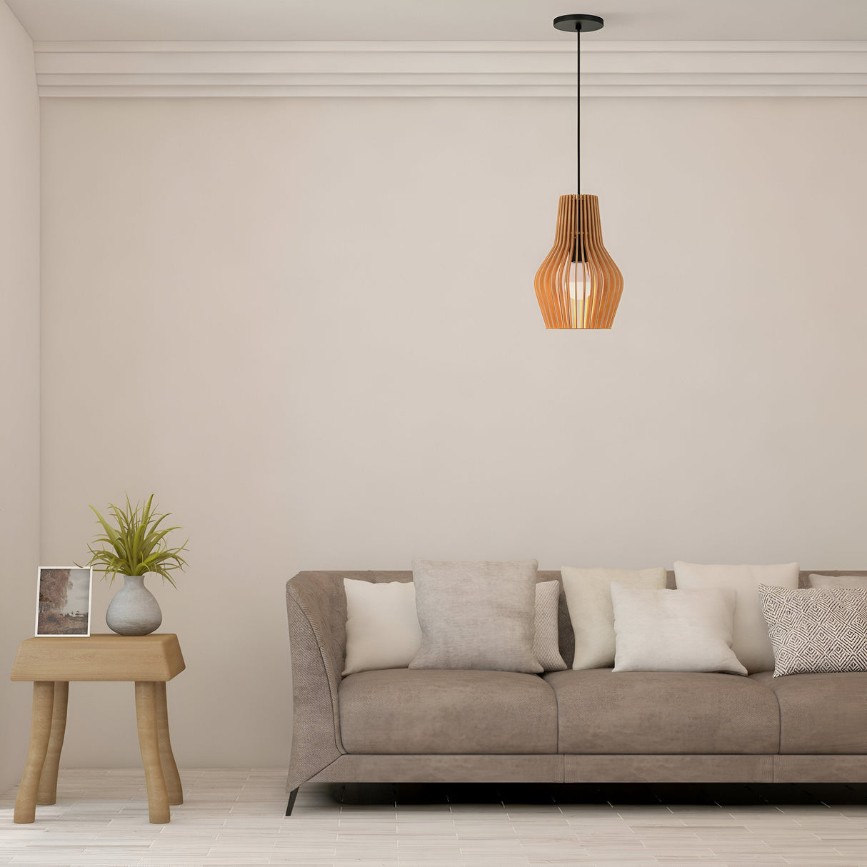 A minimalist living room showcases a beige couch with assorted cushions. A small wooden side table on the left holds a vase of greenery. Overhead, a Roots Pendant Light 30cm - Black with Beige Wooden Cone Dome Shade from the modern nature collection softly illuminates the space.
