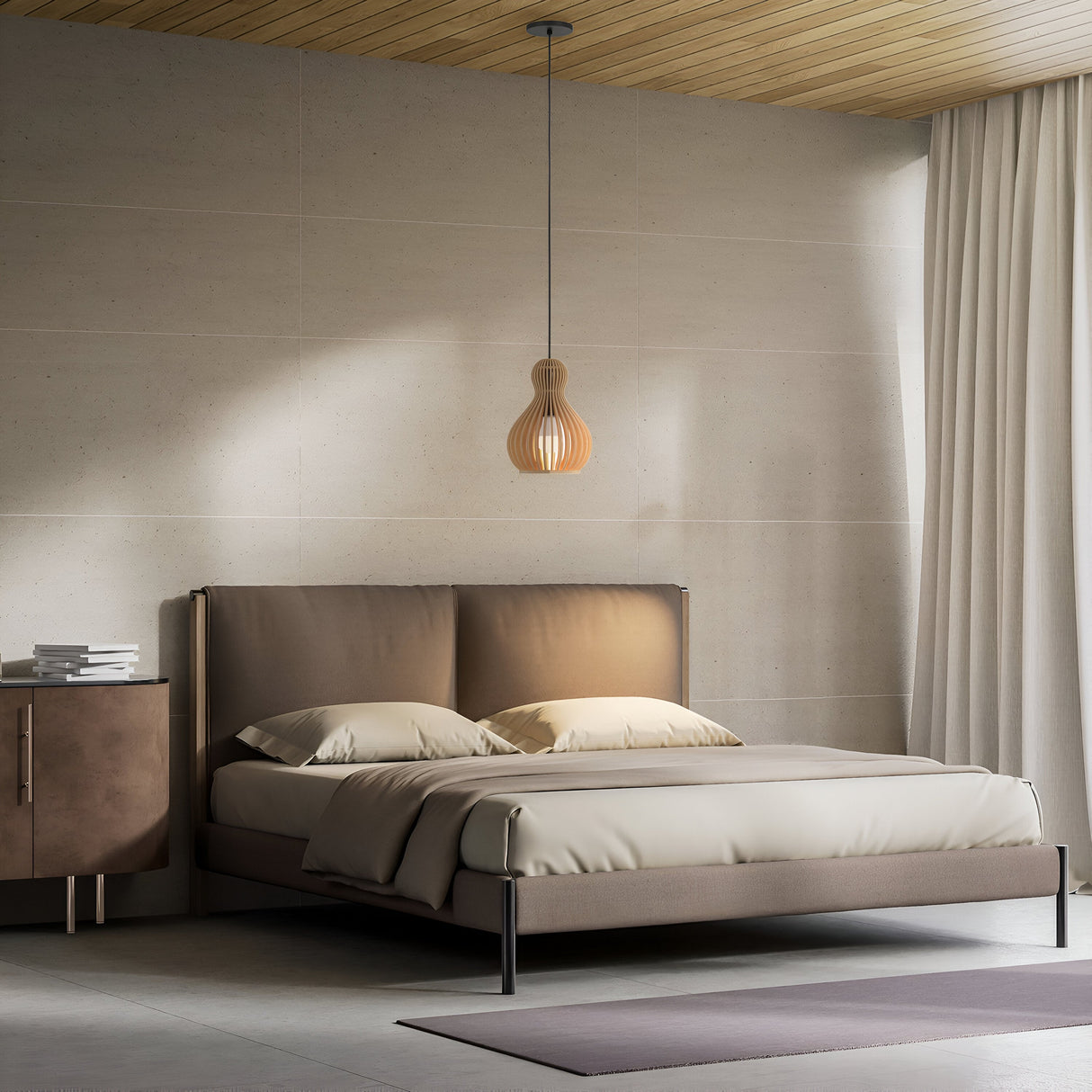 A minimalist bedroom features a double bed with tan bedding, a Roots Pendant Light 30cm in black with a beige wooden round dome shade overhead, and a dark wooden side table with stacked books. Light gray walls and a partially visible Modern Nature curtain complete the serene setting.
