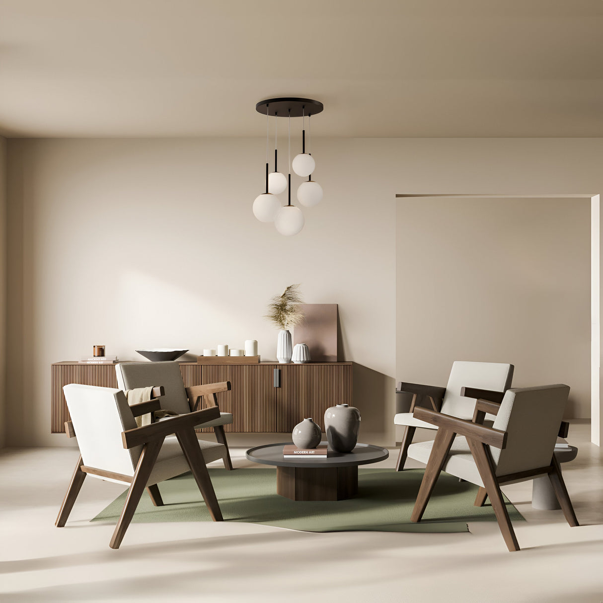 A minimalist living room features four modern armchairs around a circular coffee table on a green rug. A wooden sideboard holds candles and decor under the Basic Form 5 Light Cluster Pendant with frosted glass globes and black metal stems. Light beige walls complement the neutral palette.