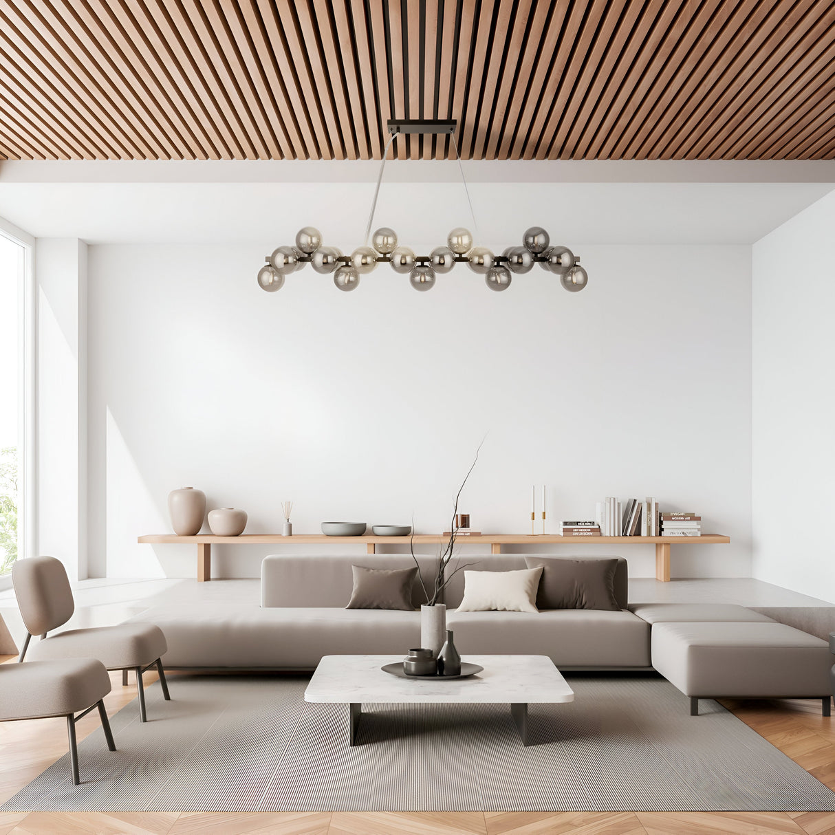 A modern living room featuring a geometrically designed chandelier, Dallas 25 Light Linear Suspension in black with smoked glass. It includes white walls, a wooden slatted ceiling, a large grey sectional sofa, a low marble coffee table, minimalist decor, and a big window enhancing the lighting.