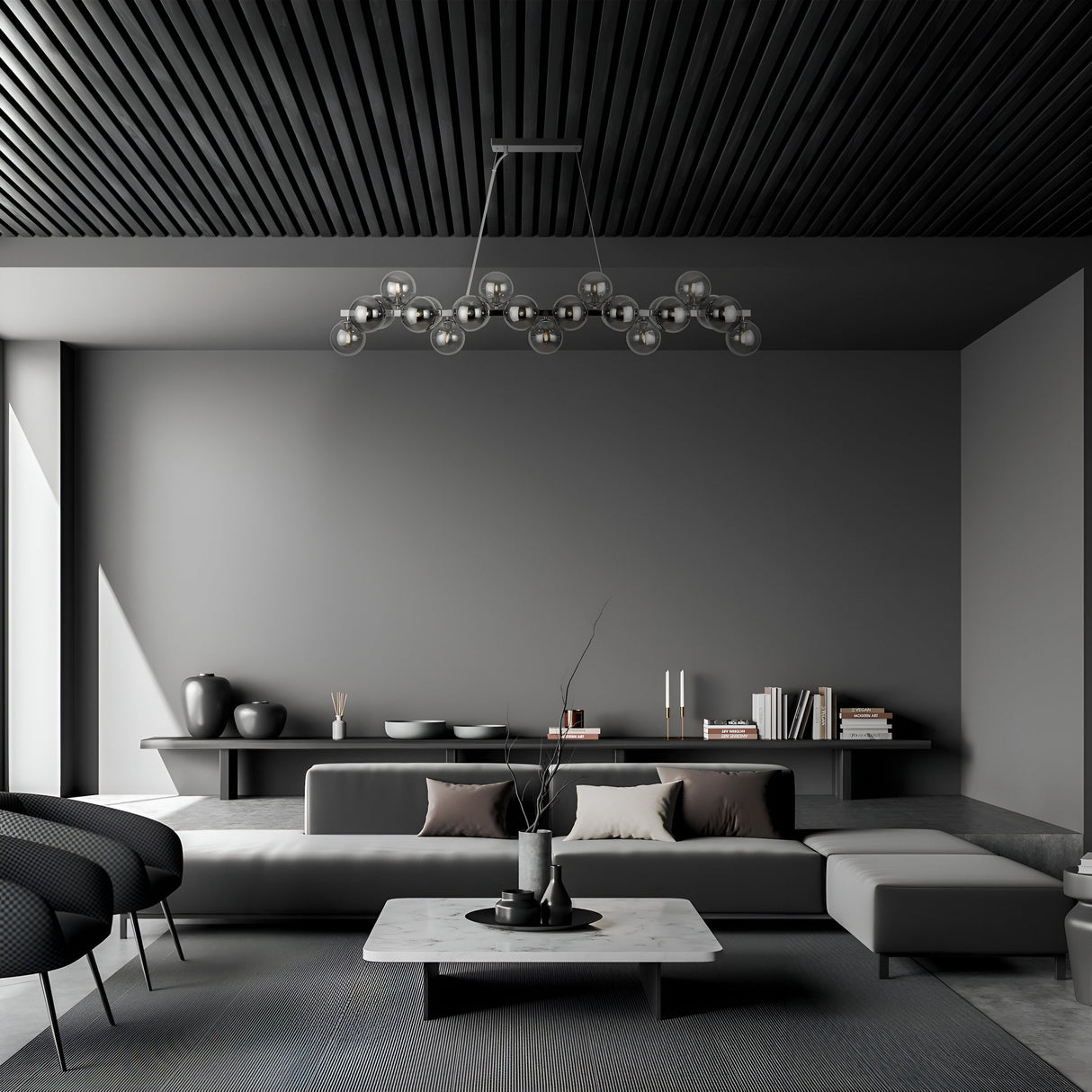 A modern minimalist living room boasts a sleek gray sectional sofa, a rectangular marble coffee table, and decorative vases. The Dallas 25 Light Linear Suspension with smoked glass enhances elegance, while light filters in through large windows under a black slatted ceiling.