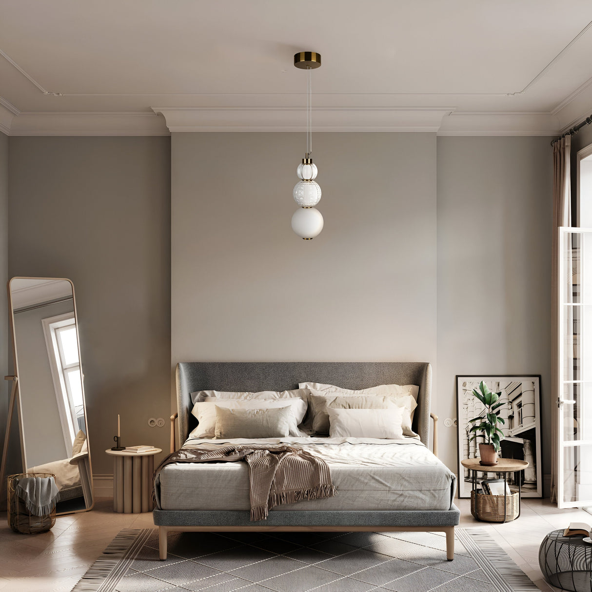 In a minimalist bedroom, a gray upholstered bed features neutral bedding and a beige throw. The Collar LED Pendant Light 16W - Gold hangs above, providing ambient light. A floor mirror and potted plant enhance the room, complemented by a geometric rug, framed art, and natural light streaming in.