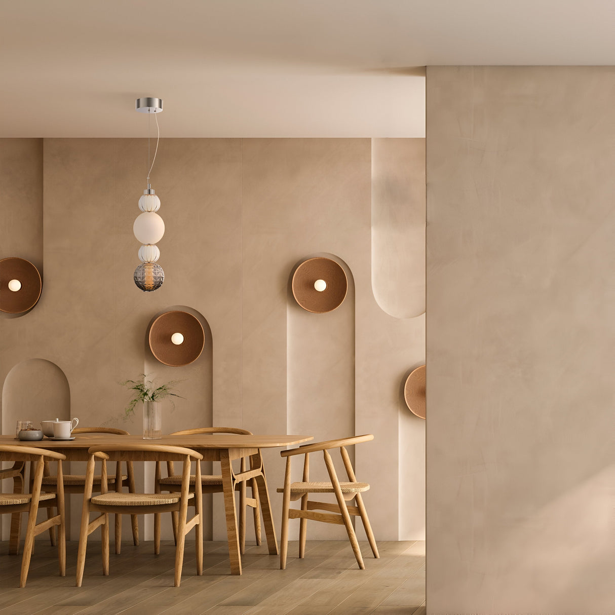 A minimalist dining room features a wooden table with six matching chairs. Beige walls have circular brown accents, and the Collar LED Pendant Light 17W - Chrome adds a modern glow. A teapot and small plant on the table enhance the contemporary vibe.