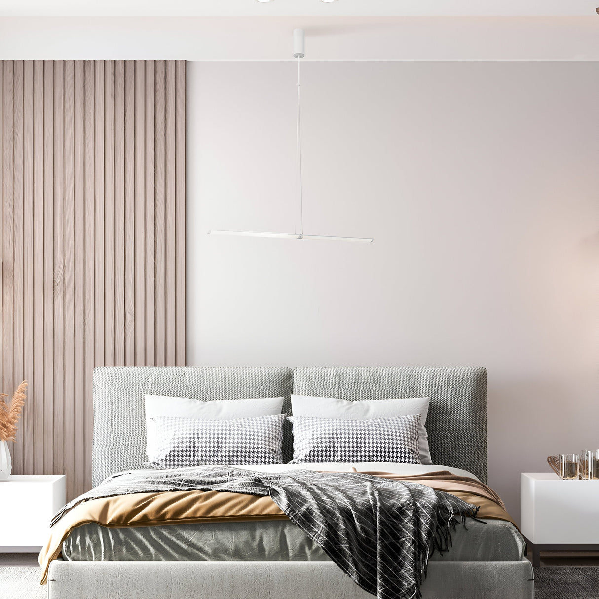 A minimalist bedroom showcases a grey upholstered headboard, white bedding with checkered pillows, and a wooden accent wall. Above the bed hangs the Supersymmetry Dimmable LED Pendant Light 21W 4000K - White, adding elegant modernity.