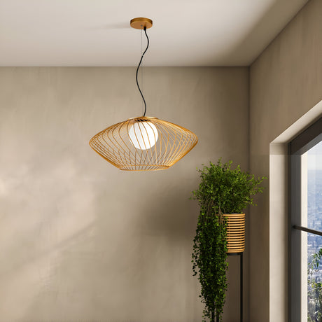 A modern room showcases the Plec Pendant Light with a frosted glass round bulb and gold cage lampshade hanging elegantly from the ceiling. A leafy plant by the window complements city views against neutral walls, enhancing the minimalist, industrial-inspired design.