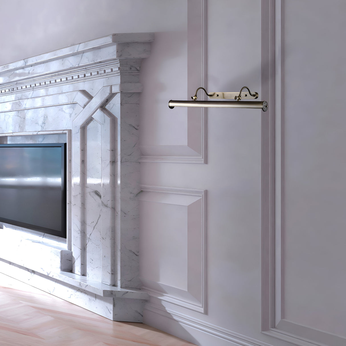 A luxurious living room showcases a white marble fireplace with a mounted TV. Elegant molding adorns the wall, complemented by an exquisite bronze coat rack. A Govanni Ribbed Picture Light - Bronze illuminates the artwork, as the light wood floor enhances the sophisticated ambiance.