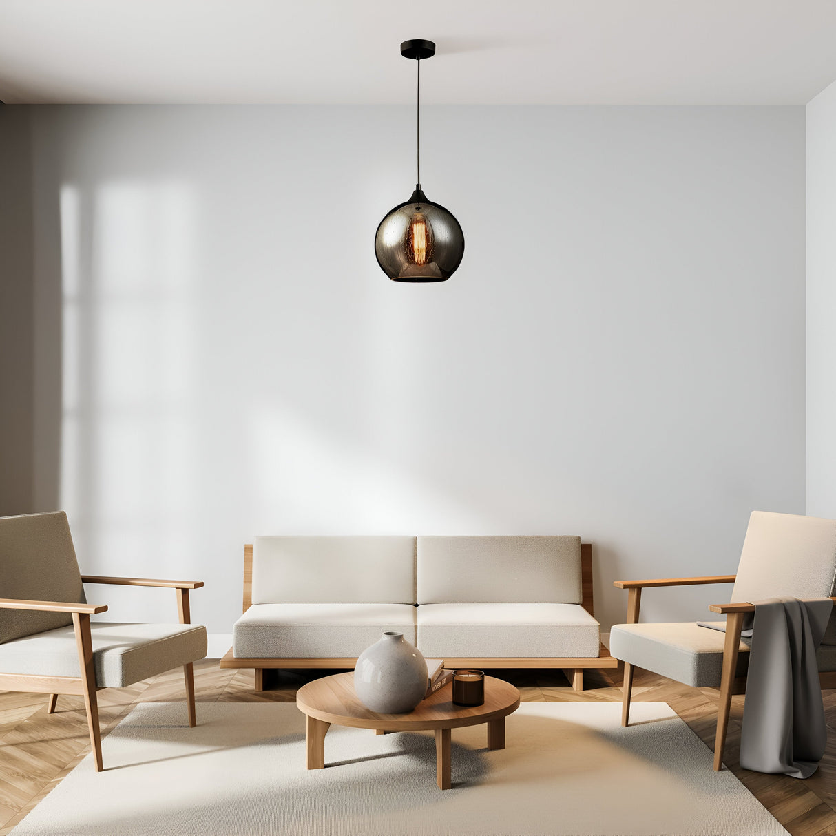 A minimalist living room features a white sofa, two beige armchairs, and a round wood coffee table with a gray vase. The Bergen Pendant Light - Black with Matt Smoky Glass Shade & Rain Jets Effect hangs from the ceiling, enhancing the neutral tones for modern elegance in this calm space.