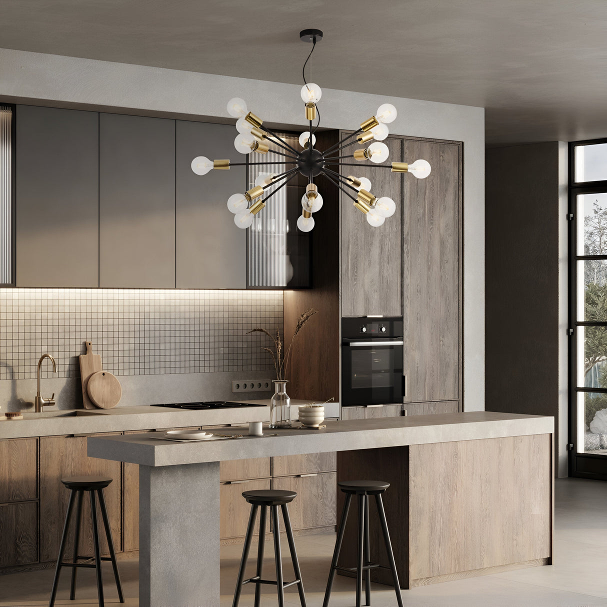A modern kitchen features a large island with three bar stools and sleek wood cabinetry. The Jackson 18 Light Chandelier - Black hangs above. It includes neutral tones, a subway tile backsplash, a built-in oven, and a window on the right.