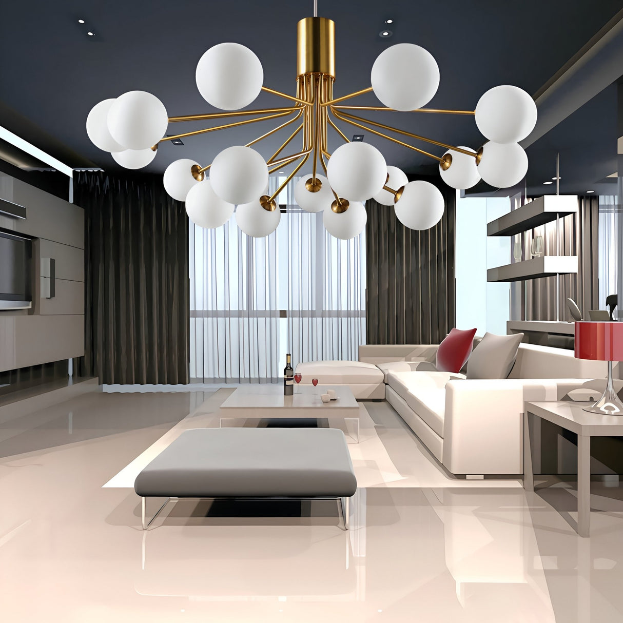 A modern living room featuring a white sectional sofa, red accent pillows, glass coffee table, the Ivy 18 Light Chandelier - Brass with opal glass shades, floor-to-ceiling windows with dark curtains, and glossy beige flooring.