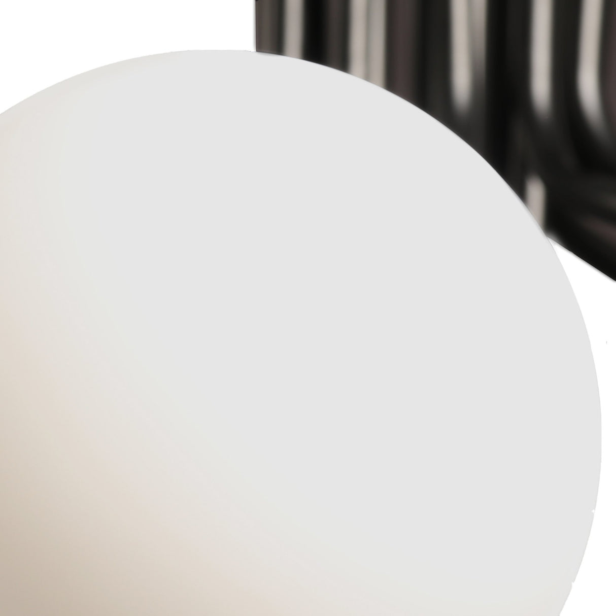 A close-up of the Ivy 9 Light Chandelier - Black shows its smooth, white glass shade in focus, while the black metal arms appear blurred in the background.