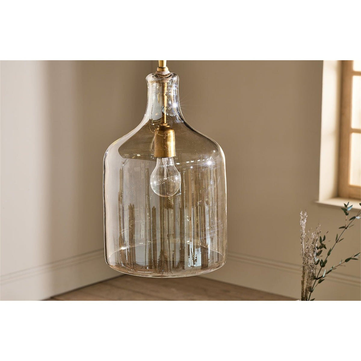Kalsi Large Recycled Glass Pendant Light in Lustre, a flagon-shaped glass shade with smoky gold tones and brass collar and lampholder, shown hanging in a neutral-toned room.